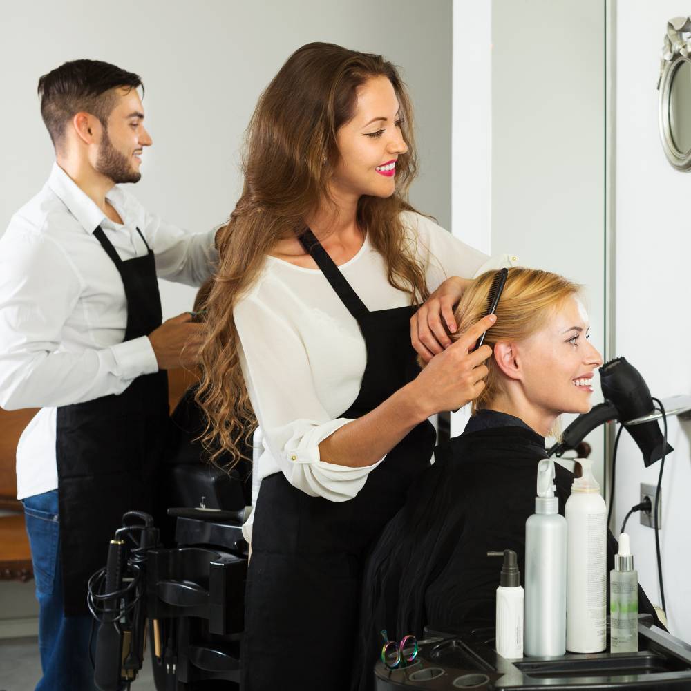 Woman styling a guests hair in a salon